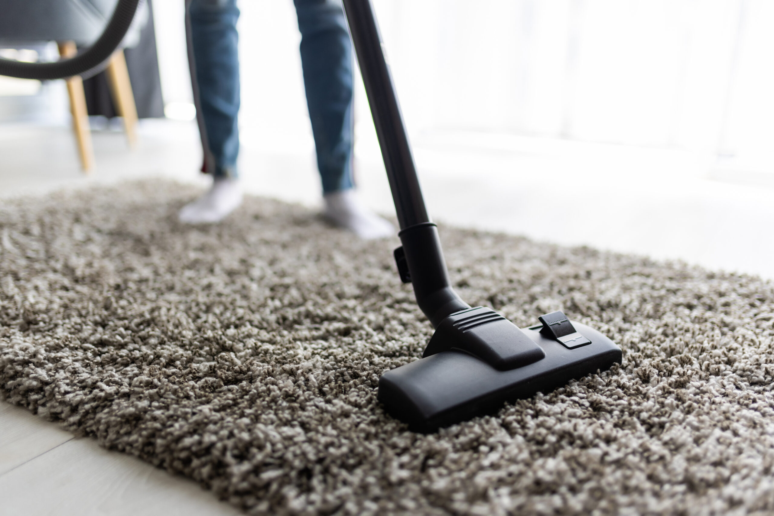 Home Repair 53 people housework housekeeping concept close up woman with legs vacuum cleaner cleaning carpet home scaled