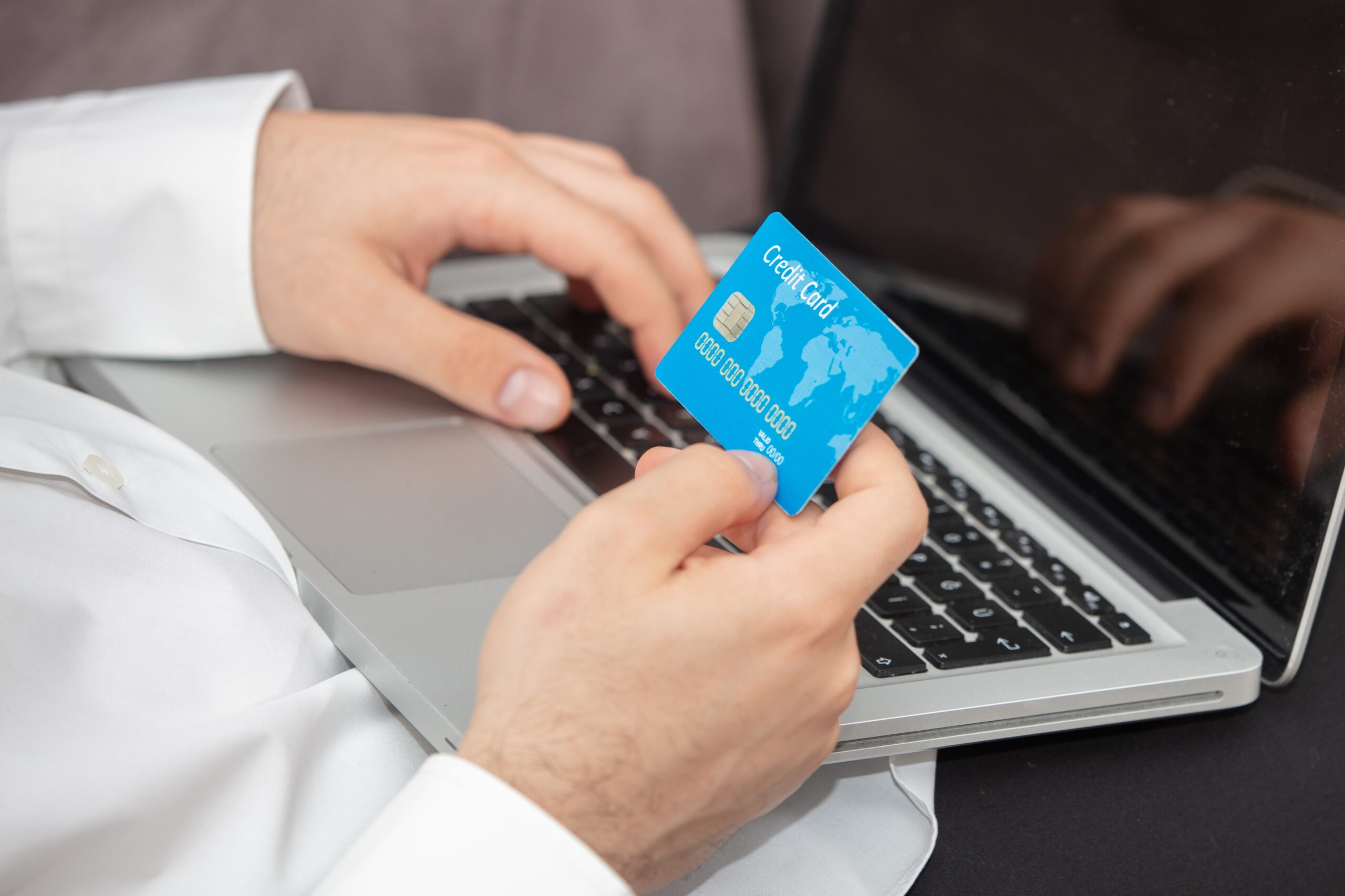 Finance 56 person inputting details its credit card laptop scaled