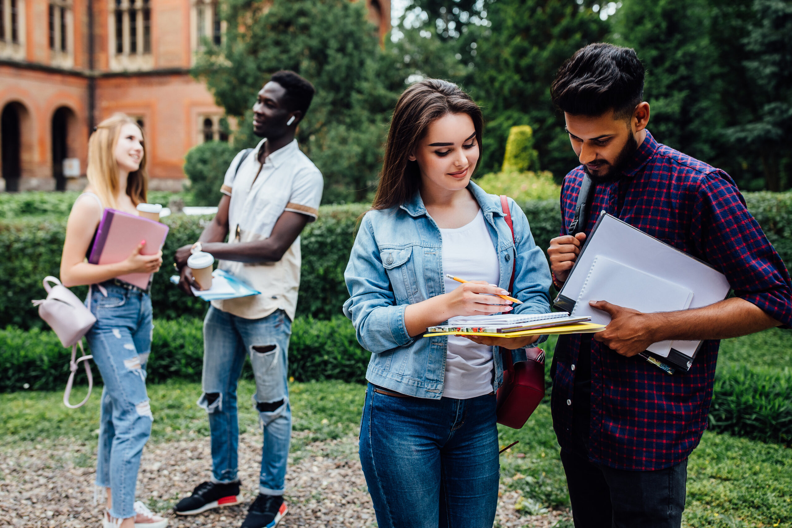 Education 53 three students talking each other outdoor college courtyard scaled